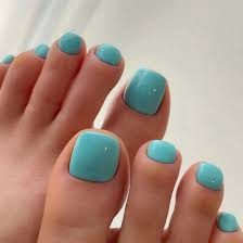 Une main affichant des ongles élégants avec une pointe française en forme de V, avec une couleur de base nude, des pointes blanches et des accents vert foncé. 